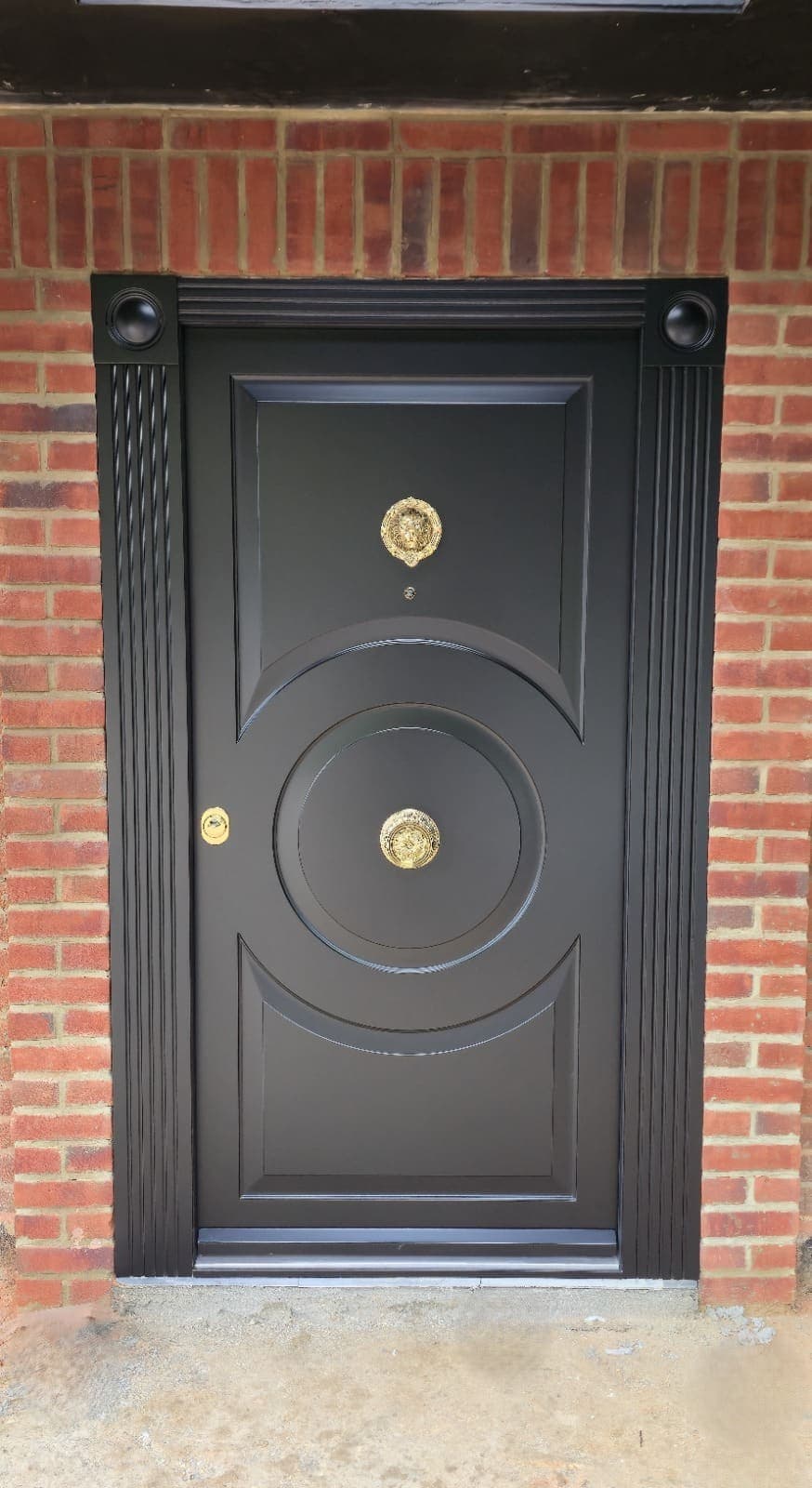 Black ornate steel door with circular fluted centrepiece