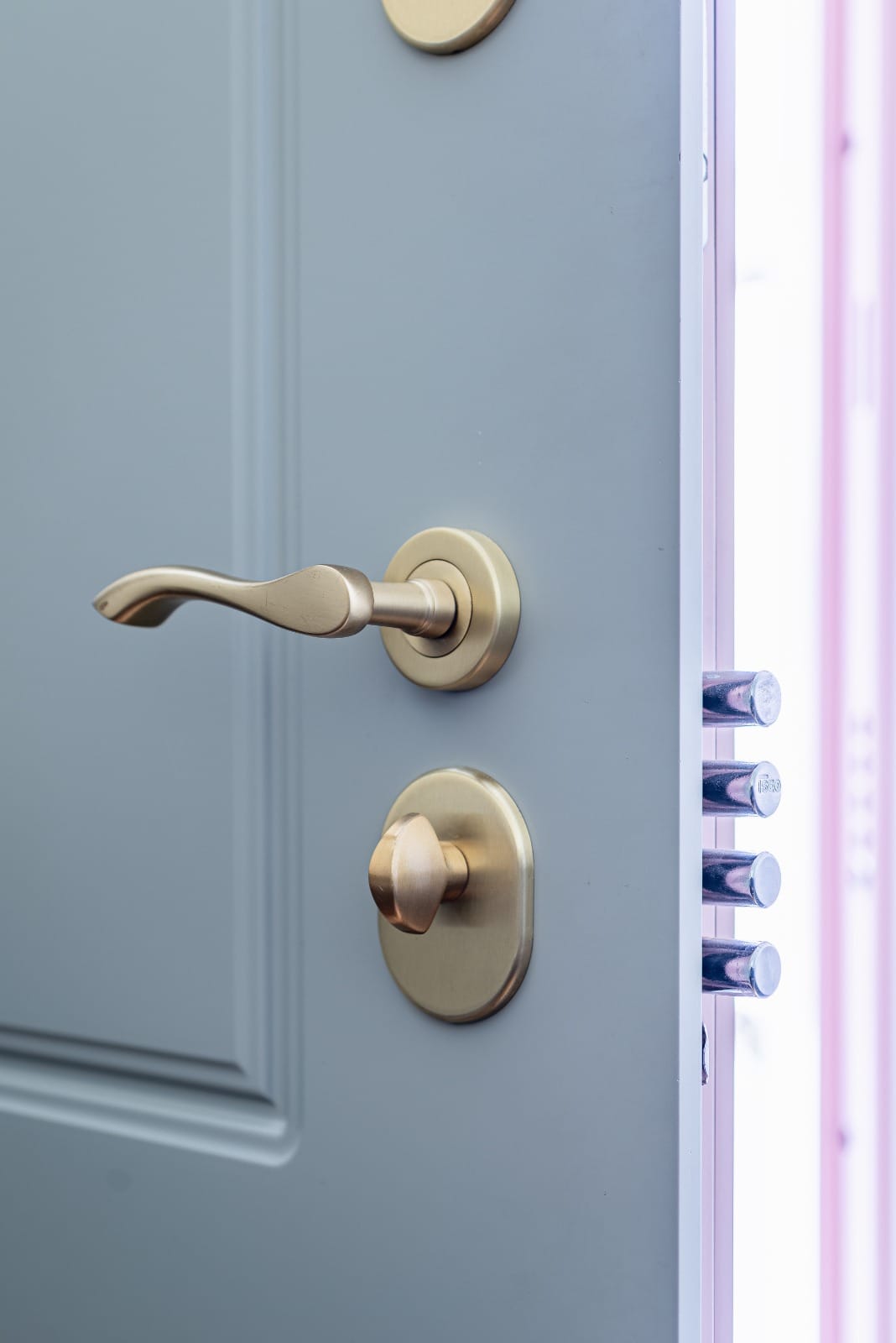 Precision brass lever handle on a grey steel door