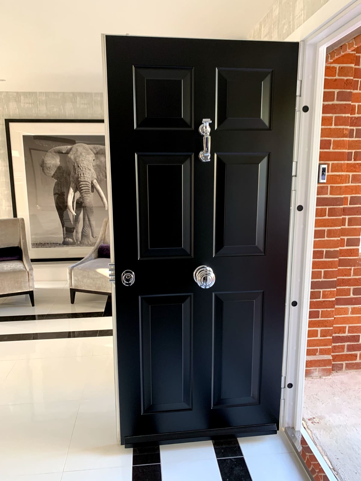 Interior view of a black steel entrance door with chrome hardware — security-rated front door