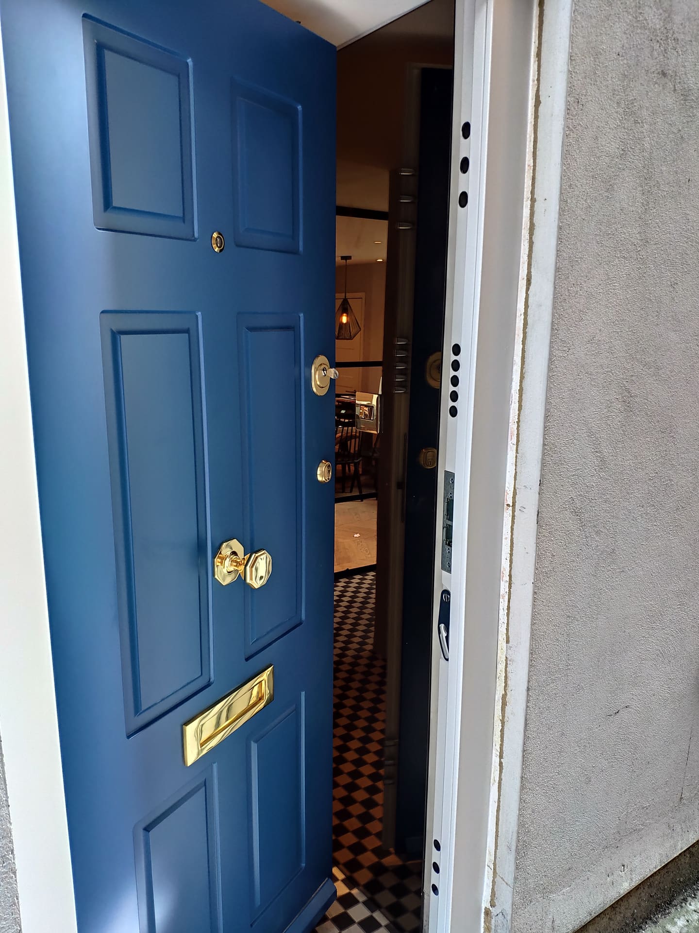 Blue panelled steel door with brass hardware detail