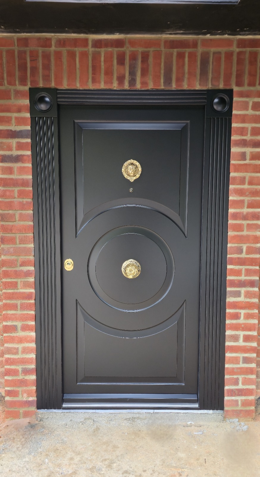 Black ornate steel door with circular fluted design