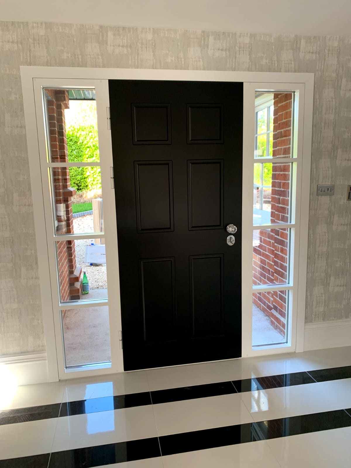 Black panelled steel door with chrome handle and sidelights interior view