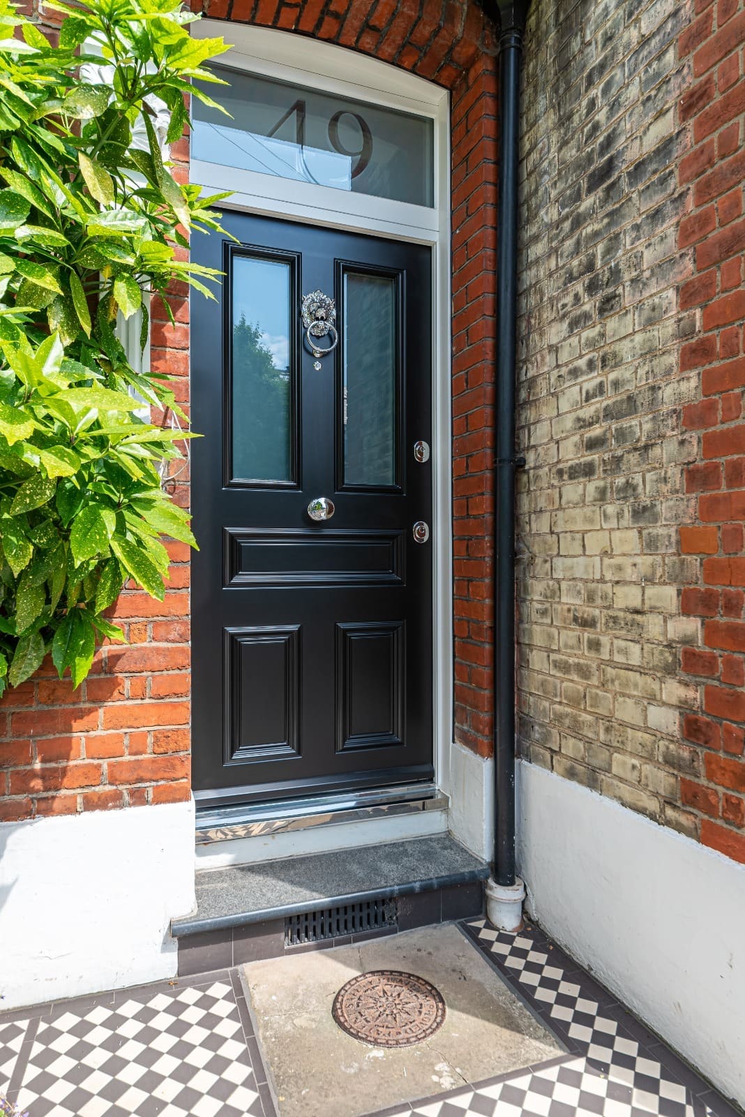 Black traditional steel door with lion knocker and fanlight