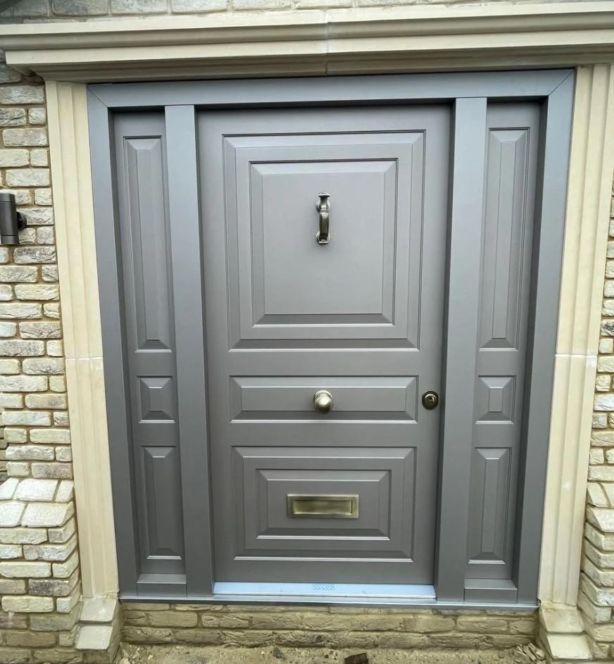 Grey panelled steel door in stone surround
