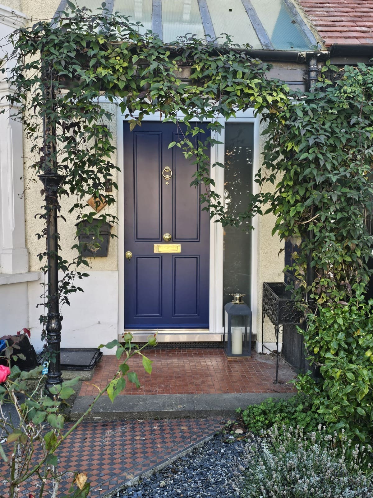 Navy traditional steel door under vine-covered porch