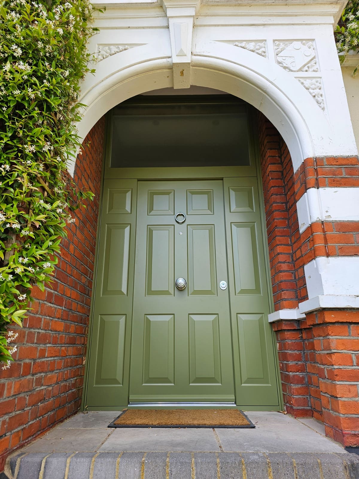 Olive traditional steel door with arched stone surround