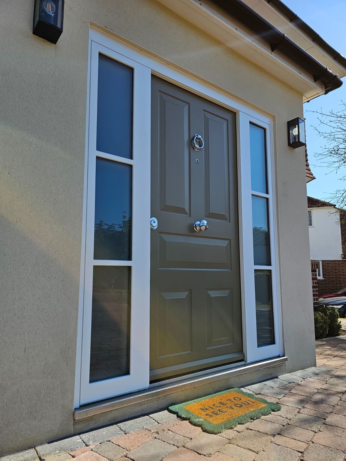 Taupe panelled steel door with dual sidelights
